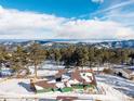 Aerial view of the home with trees, mountains, and sky at 8537 S Doubleheader Hwy, Morrison, CO 80465