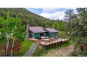 Charming home with a spacious wooden deck, outdoor seating, and a serene natural setting at 8537 S Doubleheader Hwy, Morrison, CO 80465