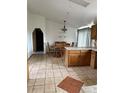 Dining area with wood table and chairs, tile flooring, and chandelier at 554 E Pleasant Ave, Byers, CO 80103