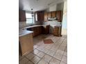 An outdated kitchen with wood cabinets and tile flooring at 554 E Pleasant Ave, Byers, CO 80103