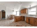 Traditional kitchen with wooden cabinets, tile flooring, and an adjacent dining area at 554 E Pleasant Ave, Byers, CO 80103