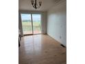 Living room with hardwood floors, sliding glass doors to deck, and an outlet at 554 E Pleasant Ave, Byers, CO 80103