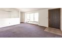 Spacious living room with carpet, lots of natural light, and easy access to front door at 554 E Pleasant Ave, Byers, CO 80103