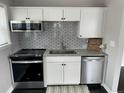 Modern kitchen featuring stainless steel appliances, granite countertops, and a stylish subway tile backsplash at 1125 Nome St, Aurora, CO 80010
