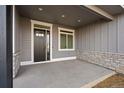 Covered front porch with stone accents and a dark gray front door at 1369 Burt Ave, Berthoud, CO 80513