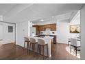 Open kitchen with a breakfast bar, wood cabinets, modern appliances, and a dining area at 7665 E Eastman Ave # D304, Denver, CO 80231