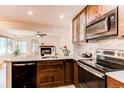A modern kitchen features stainless steel appliances, ample counter space, and rich wooden cabinetry at 4878 E Kentucky Ave # A, Denver, CO 80246