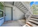 Condo entrance featuring unit number 102, with stairs to an upper level at 8065 W Eastman Pl # 6-102, Denver, CO 80227