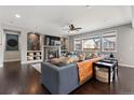 Inviting living room features a cozy fireplace, large windows, and stylish decor at 15565 E 115Th Ave, Commerce City, CO 80022