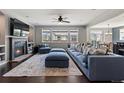 Bright living room featuring dark hardwood floors, fireplace, and ample seating at 15565 E 115Th Ave, Commerce City, CO 80022