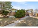 Home exterior with brick facade, mature landscaping, and a convenient walkway at 1173 Dallas St, Aurora, CO 80010
