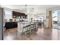 Modern kitchen with granite countertops, dark cabinets, stainless appliances and an island with barstool seating at 18809 W 92Nd Dr, Arvada, CO 80007
