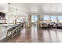 Bright, open concept living room, dining, and kitchen area with hardwood floors and natural light at 18809 W 92Nd Dr, Arvada, CO 80007