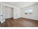 Bright, open-concept living room with hardwood floors, white walls, and large windows at 8644 Pennycress Dr, Littleton, CO 80125