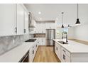 Modern kitchen featuring white cabinets, stainless steel appliances, and a center island with a sink at 42998 Colonial Trl, Elizabeth, CO 80107