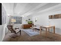 Cozy living room with beamed ceilings, neutral decor, and comfortable seating arrangement at 555 E 10Th Ave # 15, Denver, CO 80203