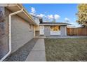 Front entrance of the home with a walkway and landscaping at 6675 S Apache Dr, Littleton, CO 80120