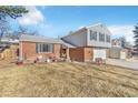 Two-story home featuring a well-manicured lawn, brick exterior and a two car garage at 8081 Johnson St, Arvada, CO 80005