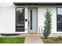 Close-up of modern front door with sleek design, vertical window, and tidy landscaping creating curb appeal at 1308 Stuart St, Denver, CO 80204
