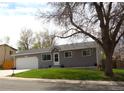 Cozy single-story home featuring a well-kept lawn, a garage, and mature trees at 19038 E Girard Ave, Aurora, CO 80013