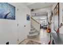 Bright entryway featuring hardwood floors, a staircase, and open access to the living area at 10232 Yampa Ct, Commerce City, CO 80022