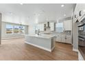 Spacious kitchen with white cabinets, island, and stainless steel appliances at 9349 Russell Cir, Arvada, CO 80007