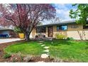 Well-manicured front yard featuring lush grass, flowering trees, and a charming walkway leading to the home's entrance at 5485 S Lakeview St, Littleton, CO 80120