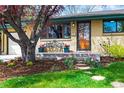 Charming brick home featuring a bench on the porch and a beautifully landscaped front yard with colorful flowers at 5485 S Lakeview St, Littleton, CO 80120