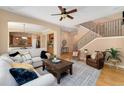Spacious living room features hardwood floors, an archway to the kitchen, and stairway to upper level at 13794 E Caley Dr, Englewood, CO 80111
