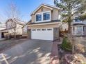 Inviting two-story home boasts a two-car garage and well-maintained landscaping at 9696 Pinebrook St, Highlands Ranch, CO 80130