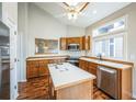 Bright kitchen features wood cabinets, an island, stainless appliances and hardwood floors at 9630 W La Salle Ave, Lakewood, CO 80227