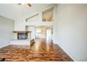 Bright living room featuring soaring ceilings, a cozy fireplace, and wood floors at 9630 W La Salle Ave, Lakewood, CO 80227