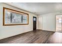 Bright living room features dark wood floors, large bay window, and neutral paint at 1390 Estes St, Lakewood, CO 80215