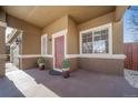 Inviting covered front porch with a stylish red door, creating a warm welcome at 7301 S Mobile St, Aurora, CO 80016