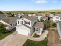 Charming two-story home featuring a covered porch, attached garage, and well-manicured landscaping at 7720 Brown Bear Way, Littleton, CO 80125