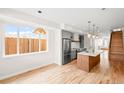 Bright, open kitchen featuring modern appliances, hardwood floors, and an island with pendant lighting at 1052 N Knox Ct, Denver, CO 80204
