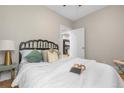 Cozy bedroom with a decorative iron headboard, soft lighting, and a view into the living spaces at 3045 Arapahoe St, Denver, CO 80205