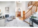 Bright foyer with a soaring ceiling, hardwood floors, grand staircase, and a fireplace at 8316 Green Island Cir, Lone Tree, CO 80124