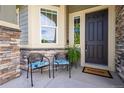 Cozy front porch features seating, a welcome mat, and stylish stone accents at 15392 W 49Th Ave, Golden, CO 80403