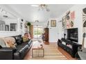 Bright living room with hardwood floors, a comfortable black sofa, and access to the backyard at 3202 S Dahlia St, Denver, CO 80222