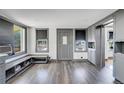 Open-concept living area with modern gray wood floors, two windows, and gray trim at 2226 Fulton St, Aurora, CO 80010