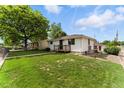 Home exterior with a green lawn, a charming side porch, and well-maintained landscaping at 4505 W Gill Pl, Denver, CO 80219