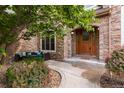 Inviting front entrance featuring a beautiful wood door, stone archway, and cozy seating area at 1313 Jade Ln, Longmont, CO 80504