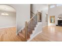 Open concept living area featuring hardwood floors, a staircase, and views of the fireplace at 1313 Jade Ln, Longmont, CO 80504