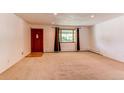 Spacious living room featuring neutral carpet, a large window, and a traditional front door at 16291 E 7Th Dr, Aurora, CO 80011