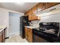 Cozy kitchen featuring black appliances and plenty of wood cabinet storage at 7770 W 38Th Ave # 207, Wheat Ridge, CO 80033