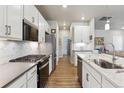 Modern kitchen showcasing stainless steel appliances, subway tile backsplash, and flowing seamlessly into the living space at 12820 Inca St, Westminster, CO 80234