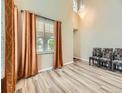 Bright living room with high ceilings, elegant chandelier, large windows, and stylish laminate flooring at 2544 S Fundy Cir, Aurora, CO 80013