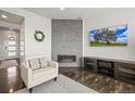 Modern living room with a fireplace, a comfortable armchair, and a sleek entertainment center at 11046 Pastel Pt, Parker, CO 80134