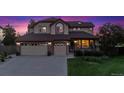 Charming home with a three-car garage, manicured lawn, covered porch, and stone accents at 4099 Starflower Rd, Castle Rock, CO 80109